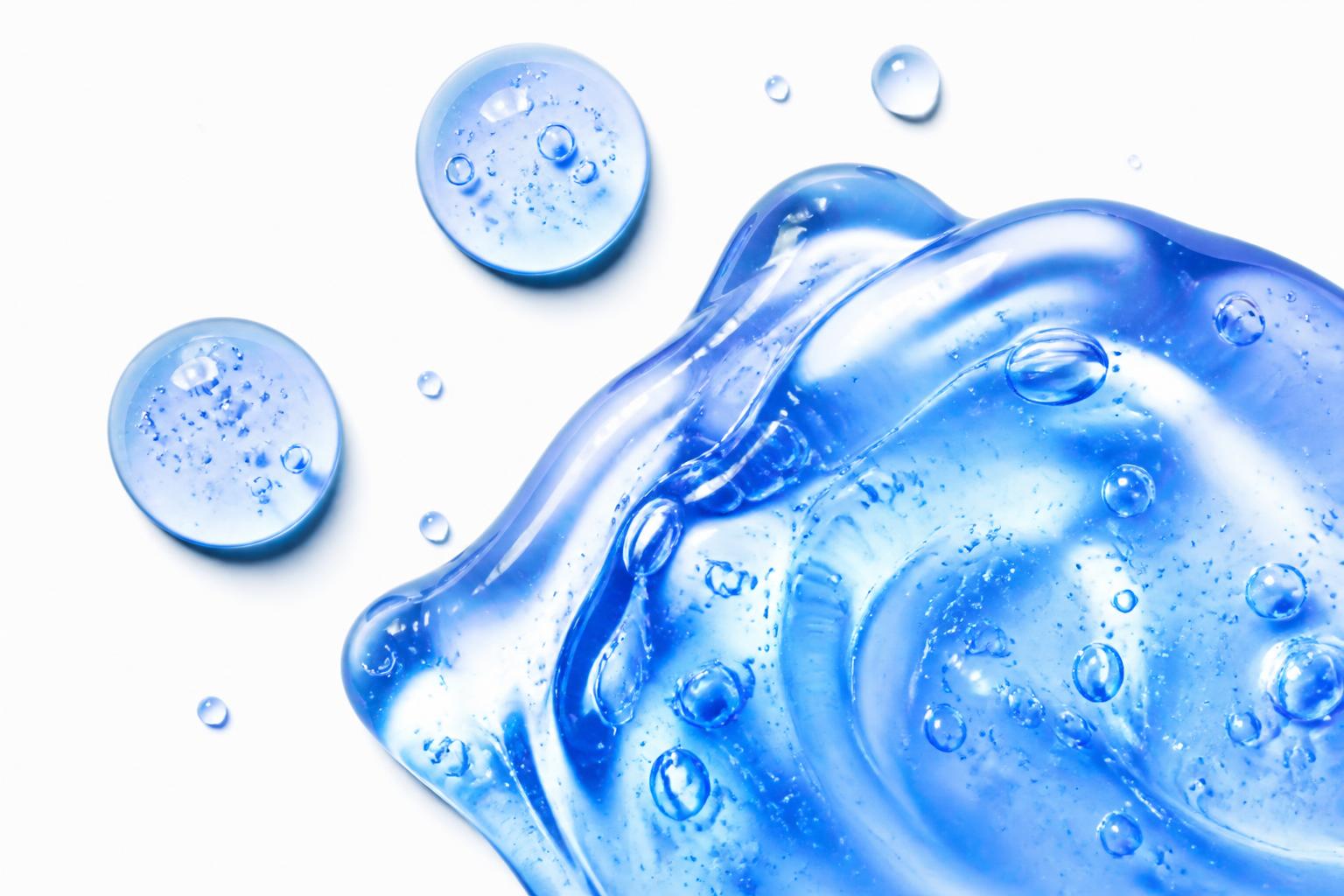 Glossy blue serum splash with bubbles